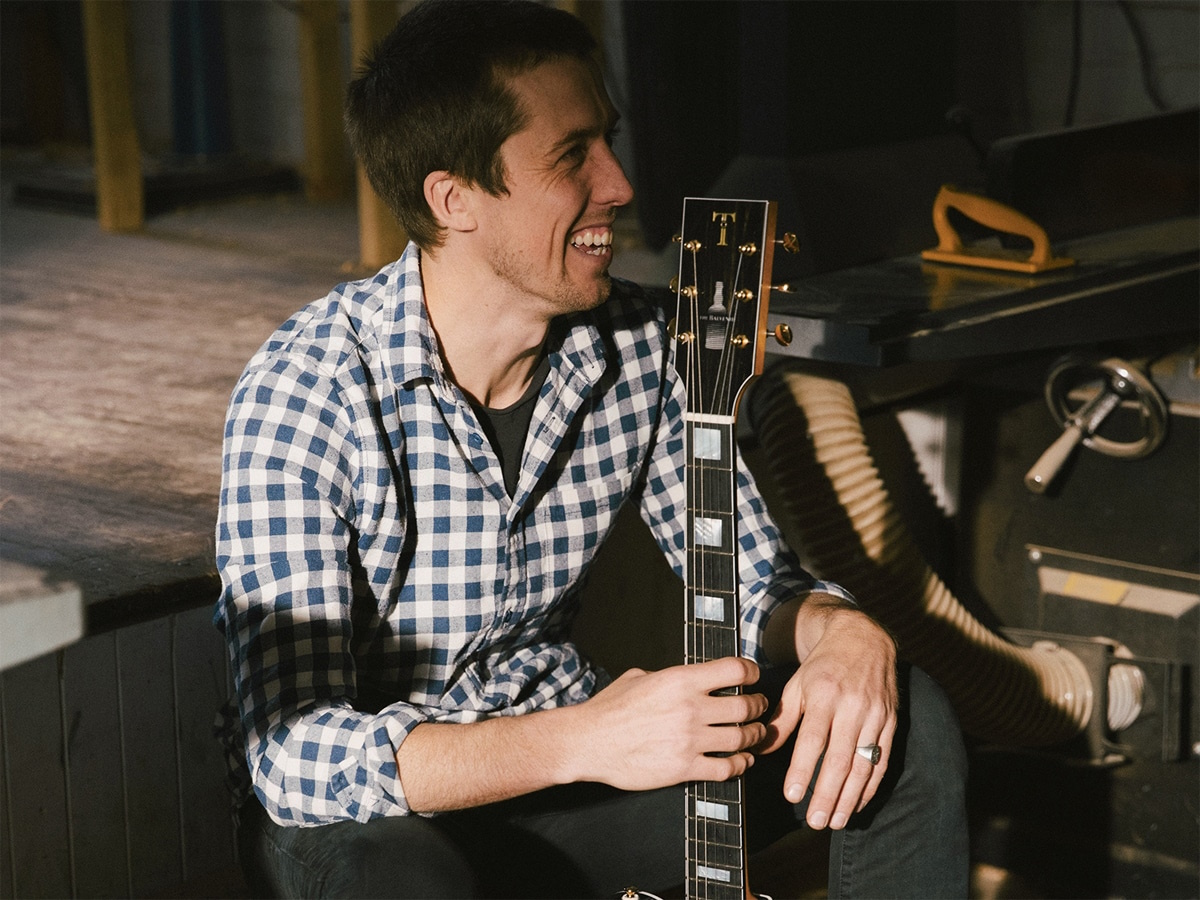 Man holding an electric guitar while sitting