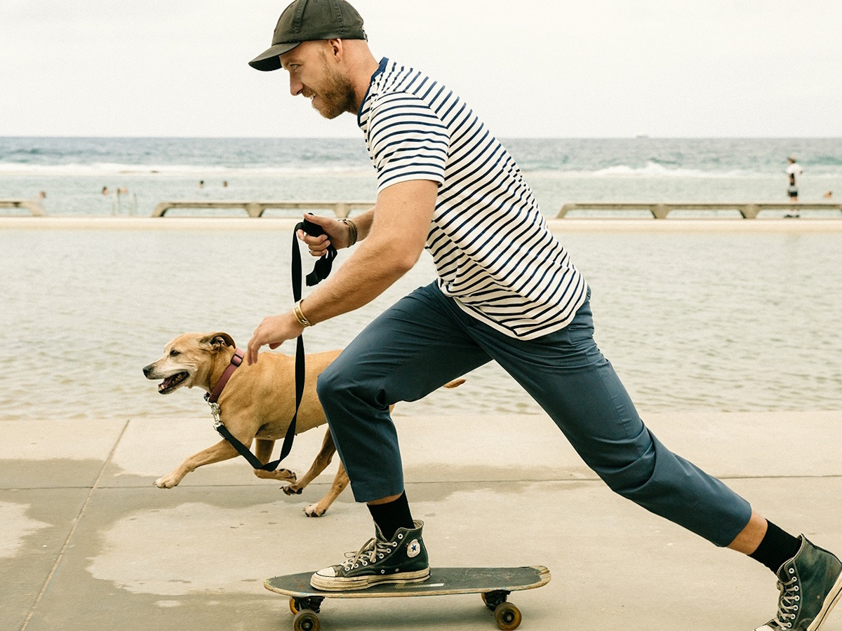 Man on a skateboard walking his dog