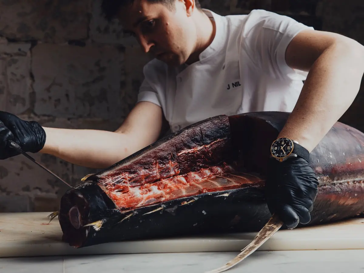 Chef cutting a big fish set on a table