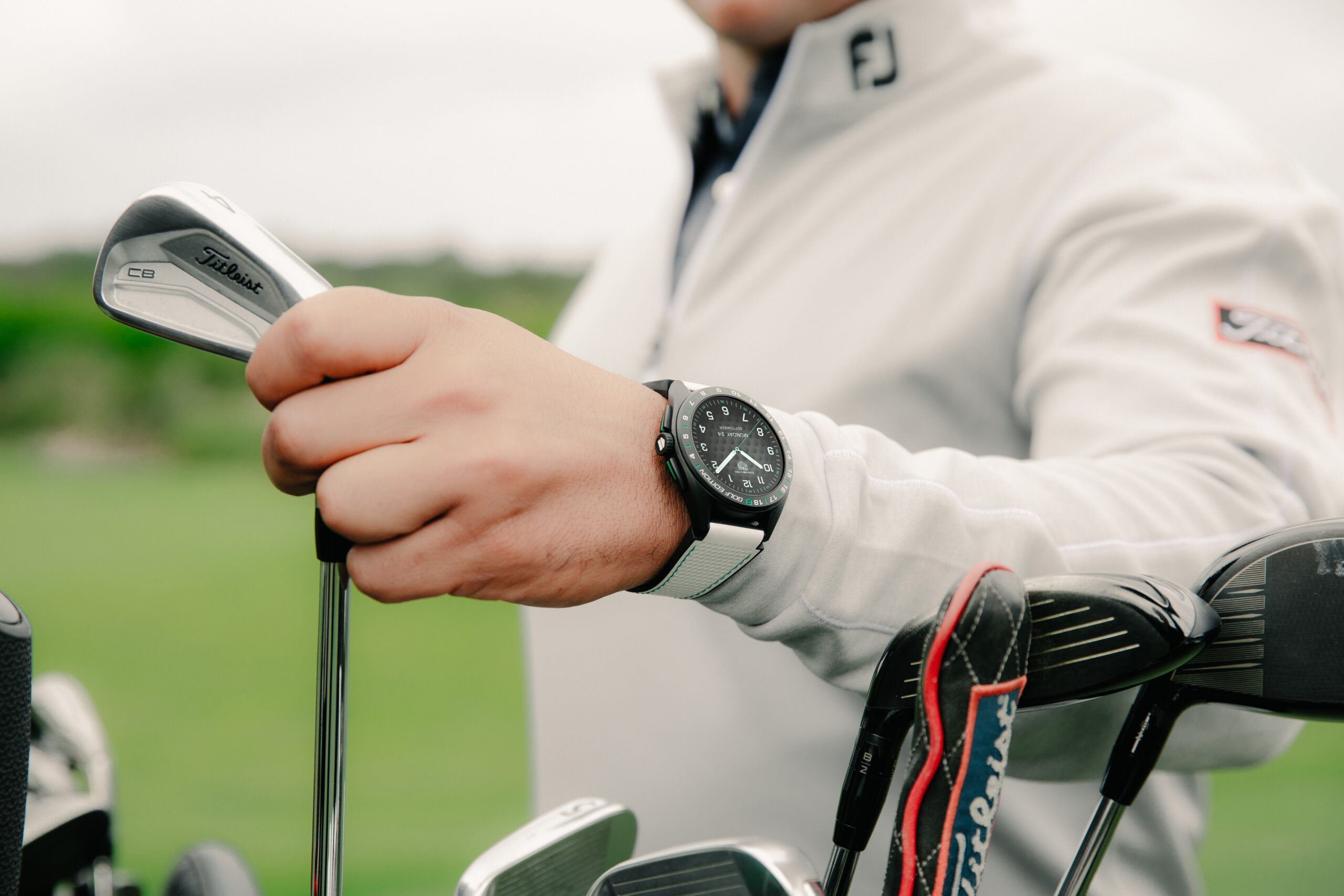 Man holding a golf club and wearing Tag Heuer's Calibre E4 Golf Edition watch