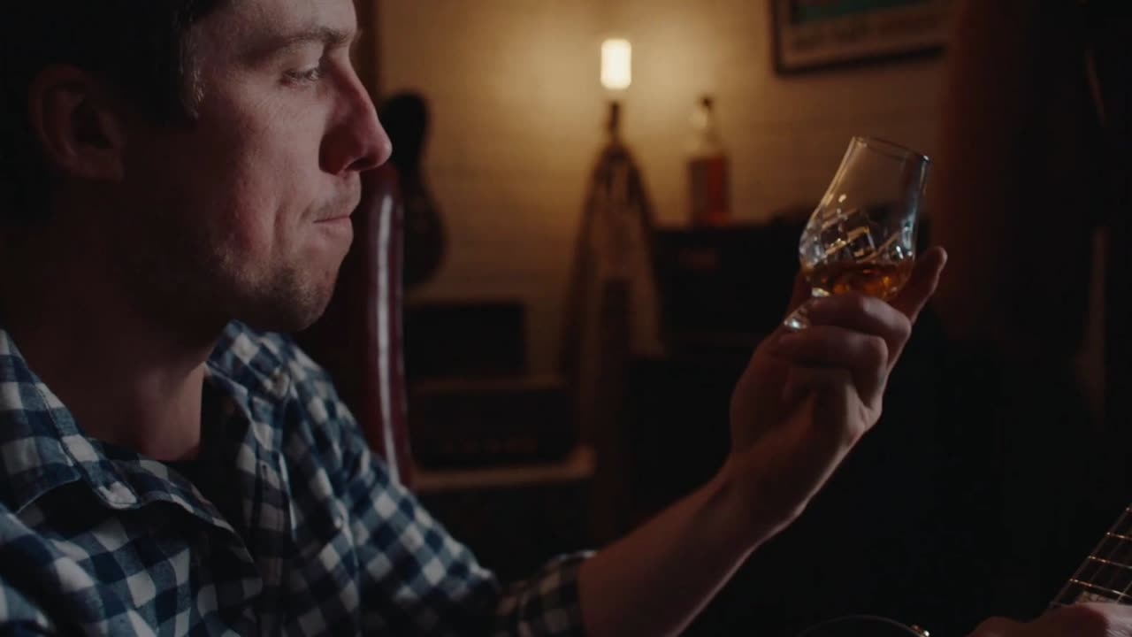 A Man of Many journalist tasting whisky on camera